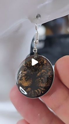 a person is holding a piece of jewelry in their hand and it looks like the inside of an earring