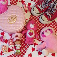 pink teddy bears and other small toys on a checkered tablecloth with red hearts