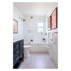 a bathroom with white tile and wood accents