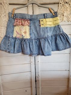 a denim skirt hanging up against a wall