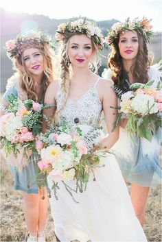 three beautiful young women standing next to each other in a field with flowers on their head