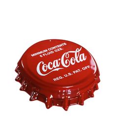 a red bottle cap with the word coca - cola on it's top and bottom