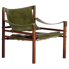 a green leather chair with wooden legs and arm rests on a white background, the seat is upholstered