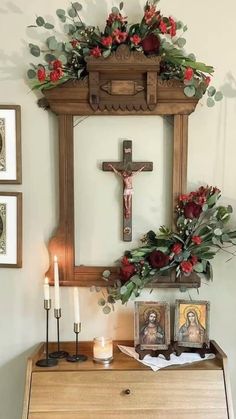 an altar with flowers, candles and pictures hanging on the wall above it in a home