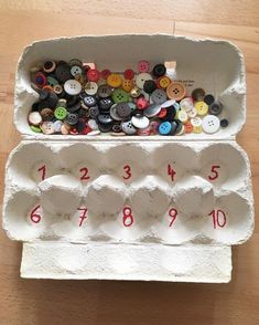 an egg carton filled with lots of different types of buttons and numbers on it