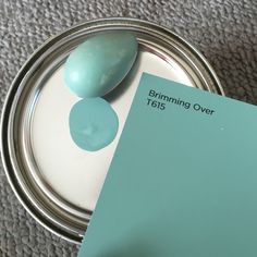 a close up of a paint can with a paper on it and a spoon in front of it