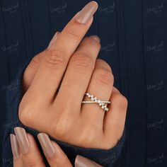 a woman's hand holding a diamond ring with three diamonds on it and two fingers