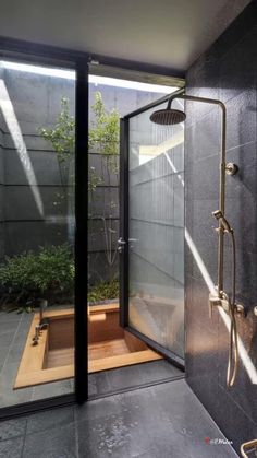 a bathroom with a walk in shower sitting next to a planter and wooden bench