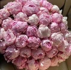 a bunch of pink peonies sitting in the back seat of a car, ready to be picked up