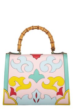 a pink and blue handbag with bamboo handles on it's handle, decorated with colorful