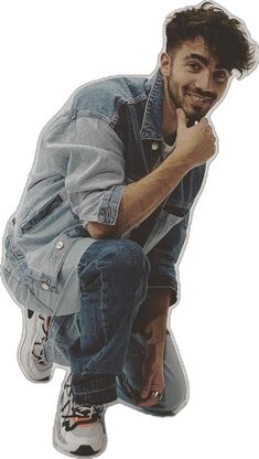 a man sitting on top of a skateboard with his hand under his chin and looking at the camera