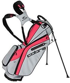 a pink and grey golf bag with two clubs attached to the back of it, on a white background