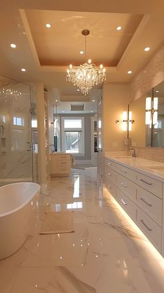 a large bathroom with white marble floors and chandelier above the bathtub is shown