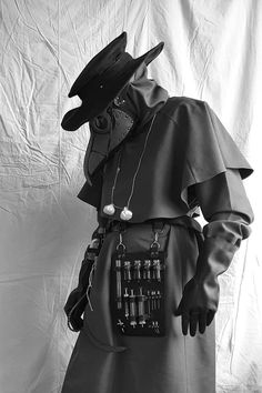 a black and white photo of a man wearing a costume with many objects attached to it