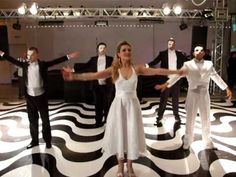 a group of people standing on top of a black and white floor covered in lights