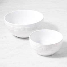 two white bowls sitting next to each other on top of a marble countertop with the word state printed on them