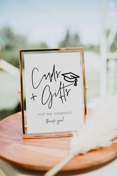 a sign that is on top of a wooden table next to a white feather ornament