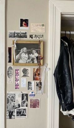 a coat hanging on the wall next to a door with pictures and photos attached to it