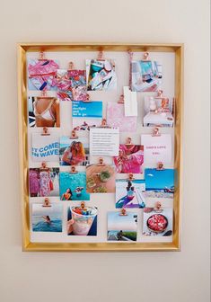 a gold frame with photos and magnets on it hanging on the wall next to a white wall