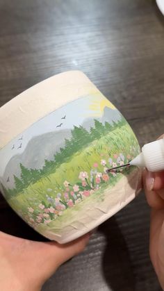 someone is painting the outside of an egg with white paint and watercolors on it