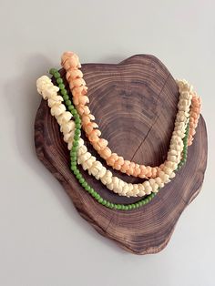 three different colored beads on a wooden plate