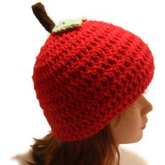 a crocheted red hat with an apple on top