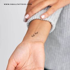 a woman's wrist with a small butterfly tattoo on her left hand and the word love written across it