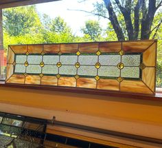 a stained glass window sitting on the side of a wall next to a window sill