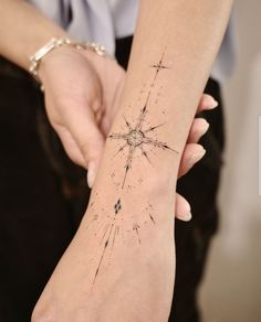 a woman's arm with a star tattoo on it