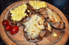 a wooden plate topped with potatoes and eggs