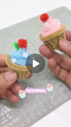 two small cupcakes with frosting and sprinkles being held by hands