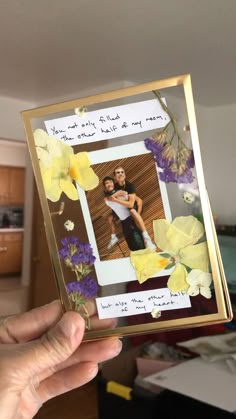 a person holding up a photo with flowers on it