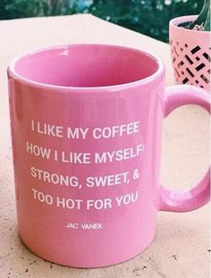 two pink coffee mugs sitting on top of a table next to each other with flowers in them