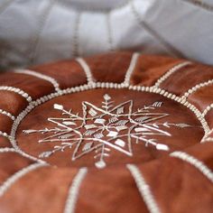 a decorative cushion with beads and snowflakes on it