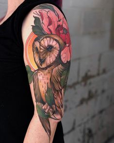 an owl and flower tattoo on the arm