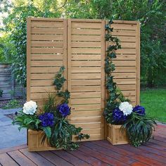 two wooden planters with blue and white flowers in them sitting on a wood deck