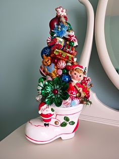 a small christmas tree is sitting on a white table next to a mirror and blue wall