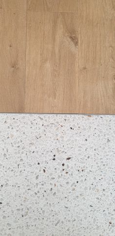 a cat laying on top of a wooden floor next to a white and brown wall