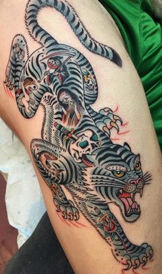 a man with a tiger tattoo on his arm and leg, showing off the design