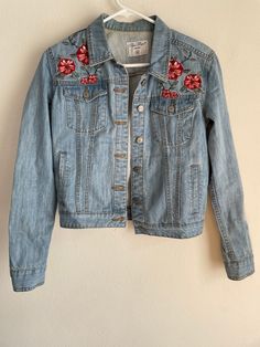 Super cute slightly Western inspired embroidered jean jacket in light wash. The floral pattern on the shoulders is super sweet and definitely 90s. Measurements (in inches flat lay):  -length: 19.5 -pit to pit: 17 (buttoned) -sleeve: 10.5  Nice vintage condition. A little bit of discoloration around the inner collar as shown in photos. Size tag says XS. Please let us know if you have any questions. Cheap Embroidered Medium Wash Outerwear, Affordable Embroidered Medium Wash Outerwear, Embroidered Jean Jacket, Embroidered Jeans, Mini Shift Dress, 60s Fashion, Size Tag, Super Sweet, Flat Lay