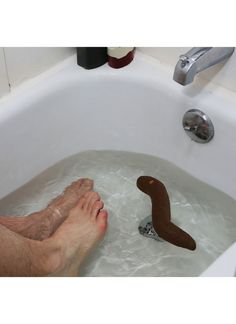 a person's feet in a bathtub with a rubber toy