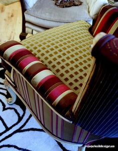 an upholstered chair with colorful pillows on it's back and seat cushion