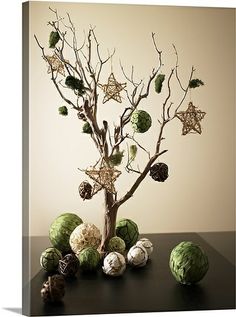 an arrangement of green and white balls in a vase on a table with star decorations