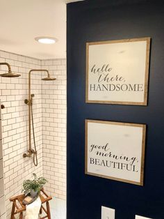 the bathroom is decorated in navy blue and white with gold accents, including two framed signs