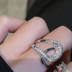 a woman's hand with two diamond rings on her fingers and one ring in the middle