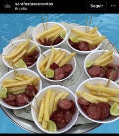 there are many different types of food on the tray next to the pool and water