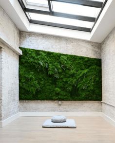 a room with a green wall in the middle and a pillow on the floor next to it