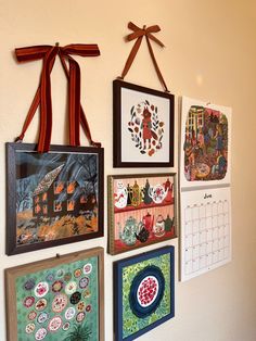 there are many pictures on the wall with ribbons hanging from it's hooks,