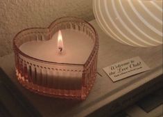 a heart shaped candle sitting on top of a table