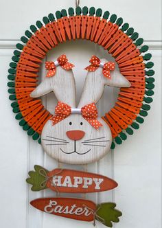 a happy easter sign hanging from the side of a door with an orange and green wreath